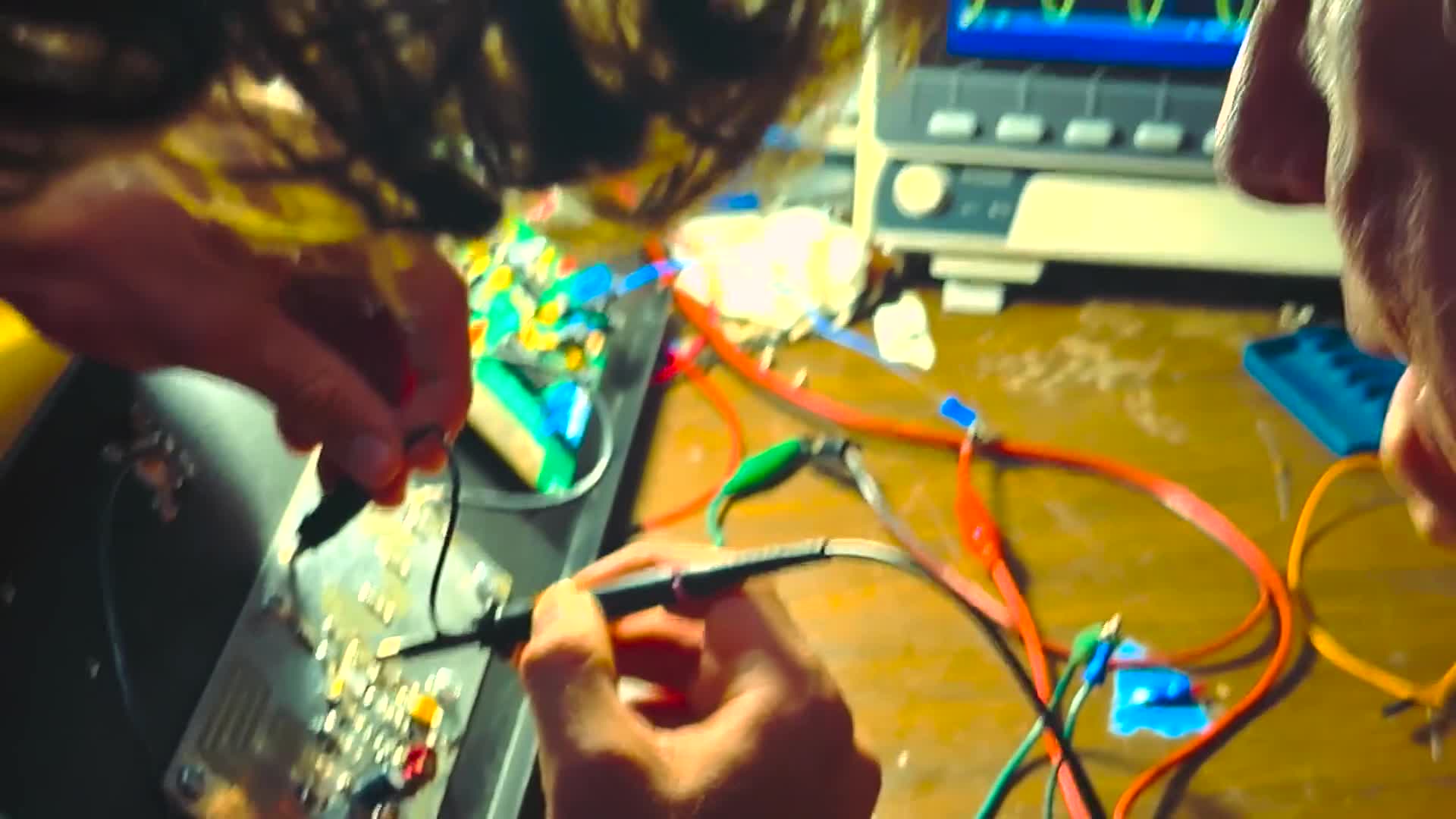 Hands soldering a radio transmitter circuit board at a Free Radio Berkeley workshop